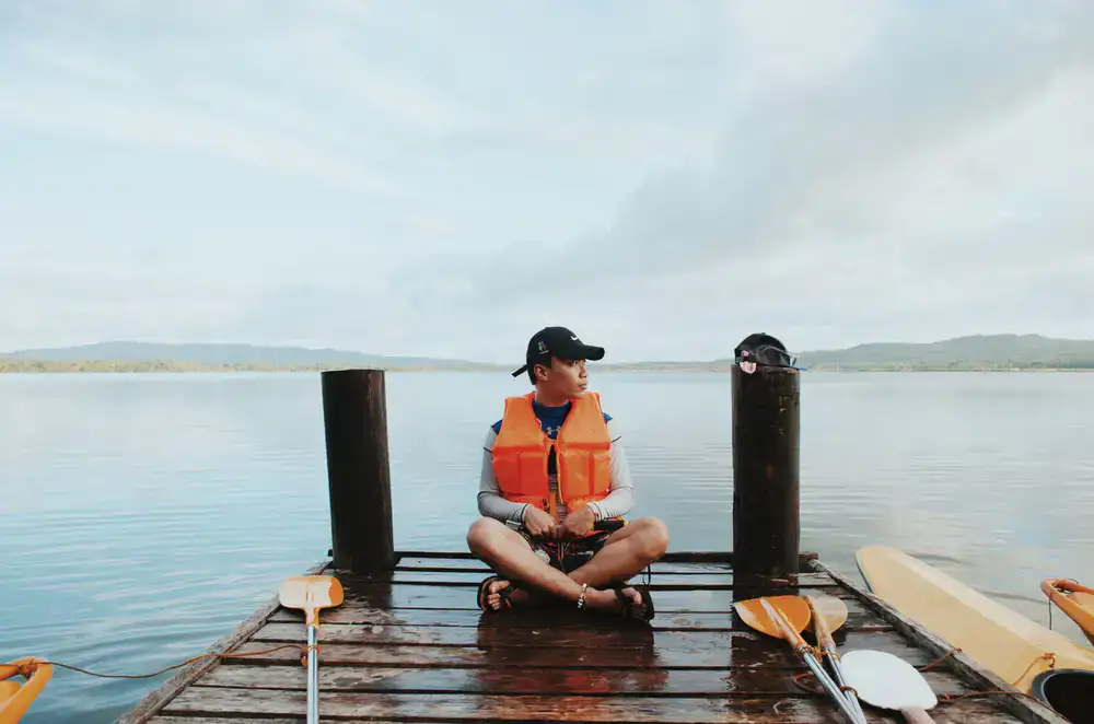 Life jackets and paddles on a wooden dock