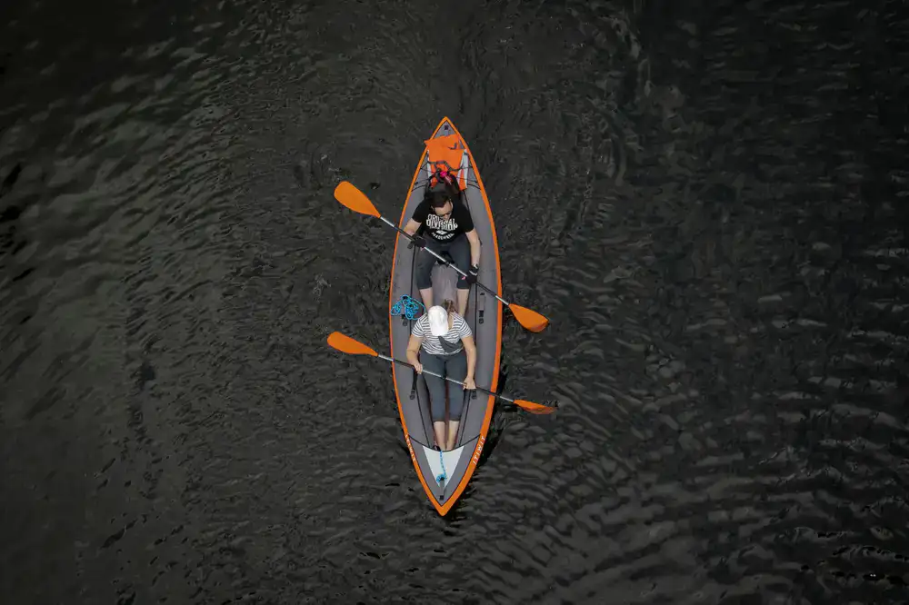 A classic tandem canoe resting calmly on the water surface