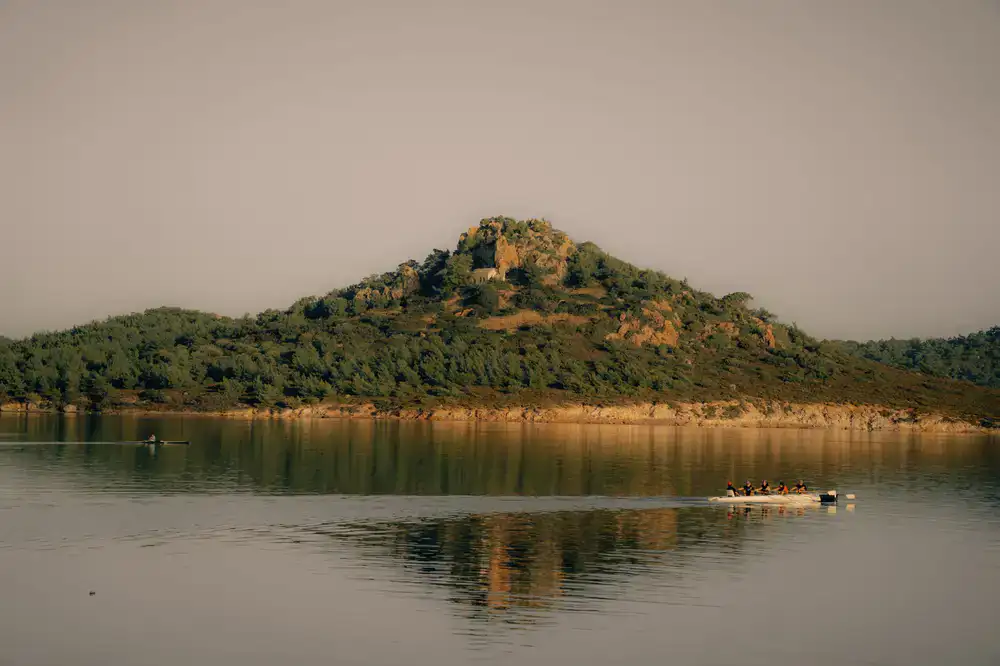A group kayaking on a calm lake at sunrise